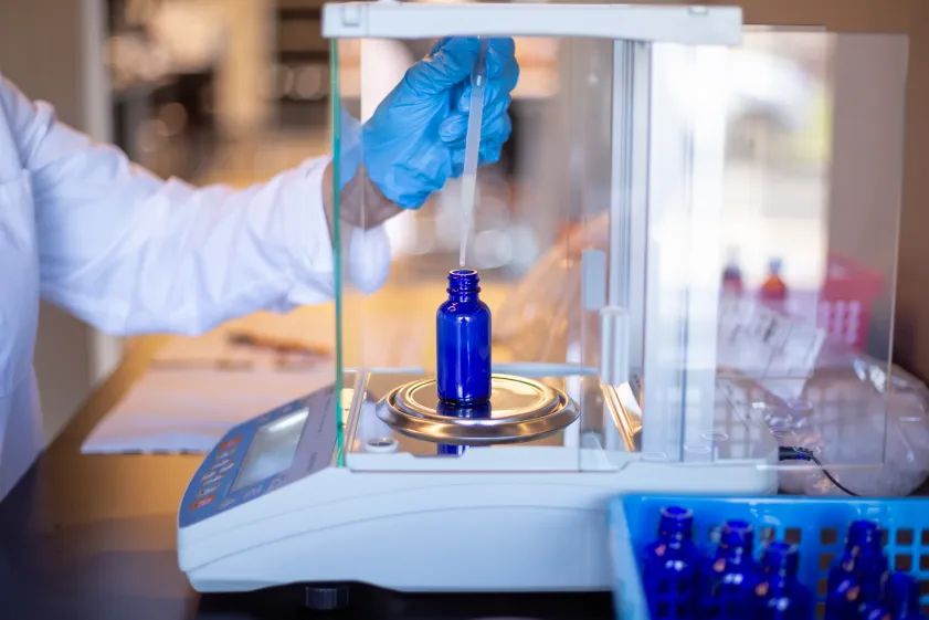Custom compounded prescription being prepared and measured in pharmacy lab